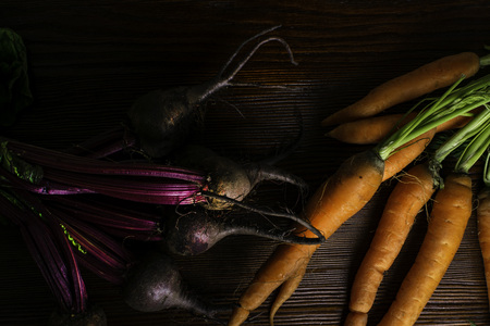 different fresh farm vegetables, organic beetroots and carrots on rustic wooden background.