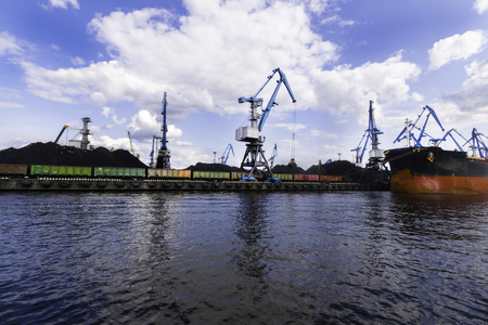 Large red cargo ship loading with a coal in the port, terminal, crane, containerの写真素材