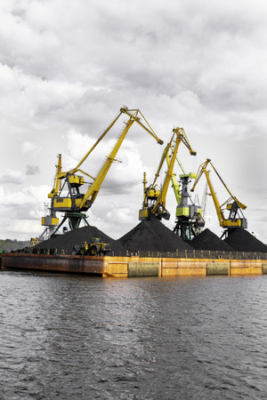 Industrial view. Working crane in the port, The Cargo in the Port Pier at the Loading of Coal. Loader and conveyors to transport coal.の写真素材