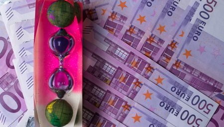 EURO banknotes, color hourglass with world on 500 notes background. Concept - time to travel