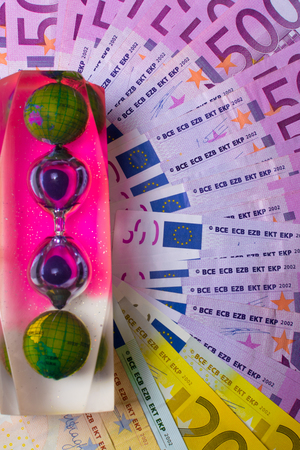 EURO banknotes, color hourglass with world on 500 notes background. Concept - time to travel, save moneyの写真素材