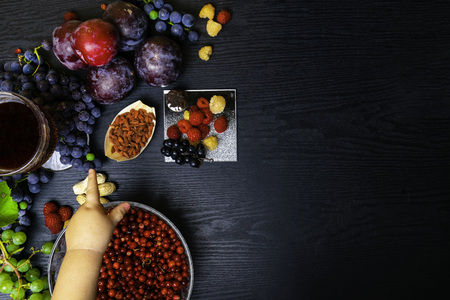 food rich with resveratrol, grapes, plums, goji, peanuts, cranberry,raspberrys dark chocolate, red wine on black wooden background, foods for a healthy breakfast - fresh berries, fruits, nuts, pomegranate juiceの写真素材