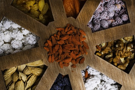 Mixed Nuts on grey background, as apricot, raisins, walnuts, goji, peanuts in glaze, almonds Healthy food and snack. vitamins, fiber, pectin, iron, potassium, calcium vitamin K E boron Top viewの写真素材