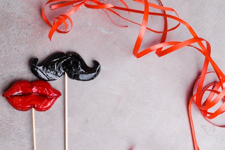 carnival party accessories candy women red lips and man mustache on a grey stone background, love concept, man and women, 14th february, weeding, heterosexualの写真素材