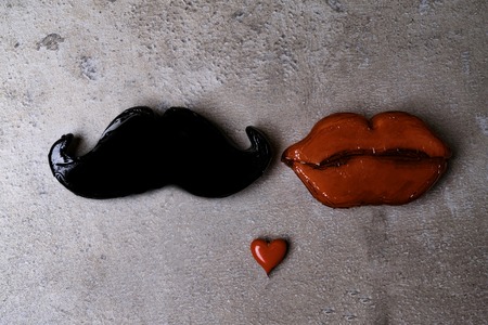 Photo booth props mustache, lips on stone grey board background. Birthday and Party Set and wedding. Couple love and sex concept, copy space for your text male and female conceptの写真素材