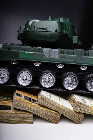 Close up green tank toy placed on euro banknotes pile. business and economy war. new world war from...