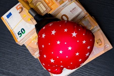 red with stars boxing glove and cash money. Concept of bribery, dishonesty in sport, greed. Isolated on blackの写真素材