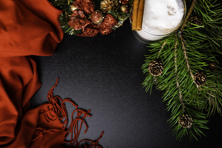 Christmas composition of wreath, glass of coffee, cinnamon sticks, bumps, branch on wooden board. Flat lay. Top view. Copy space.の写真素材