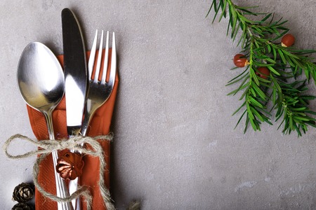 Christmas and New Year table setting. Holiday decoration, spoon, fork, knife on napkin, with rope,...