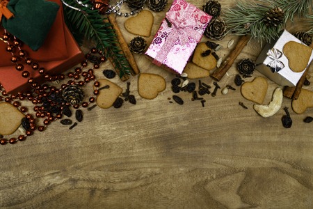 Christmas  with cookies, gifts, fir branches and spices on the old grunge wooden board.