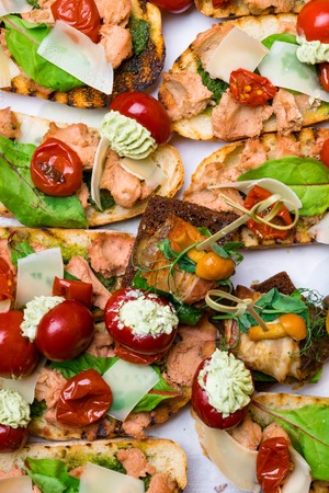 Delicious Italian antipasti bruschetta with tomato, meat pate, olives and tuna cream, mozzarella . Set of tasty appetizer sandwiches. close upの写真素材