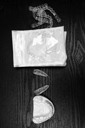 teeth alignment process, gypsum cast, different aligners in packing, straighten your teeth concept on black backgroundの写真素材