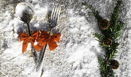 Christmas and new year silverware for celebration as invitation design background with green branch and red bows, winter snowy dayの写真素材