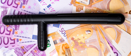 police baton on euro banknotes money cash background. Corruption, dirty money, gambling or financial crime ideas concept.の写真素材