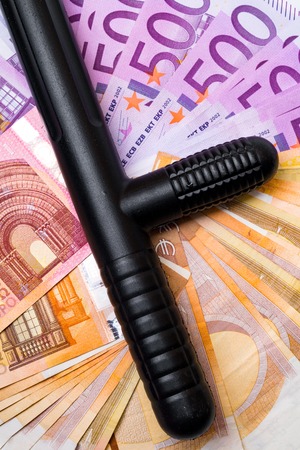 police baton on euro banknotes money cash background. Corruption, dirty money, gambling or financial crime ideas concept.の写真素材