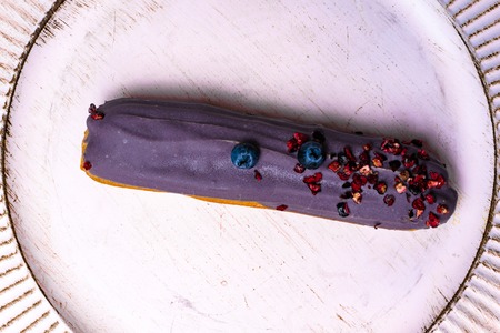 Delicious eclair on white background, top view