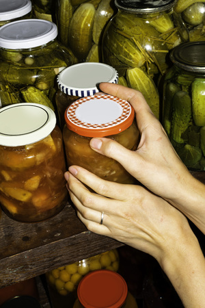 Woman puts jam jars in the basement, for storage for a long time.の写真素材