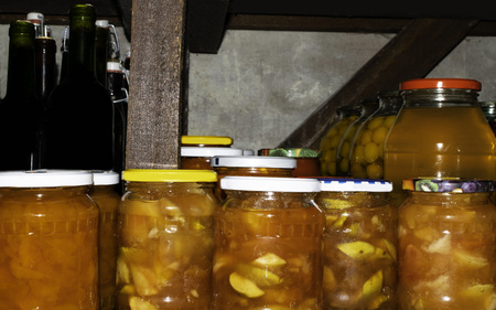 Preserves in jars in home basement. Wine in bottles, compot with cherry plum, of stocks kept for the winterの写真素材