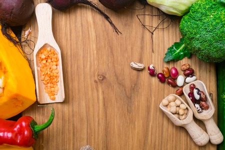 Fresh vegetables and legumes in wooden board. Organic food. Vegan food ingredients. Healthy eating concept copy spaceの写真素材