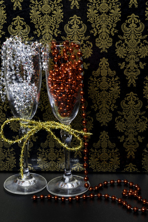 two glasses on celebratory table, decorated with gold ribbon, garlandsの写真素材