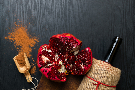 food rich with resveratrol and iron, red wine in bottle, pomegranate, cacao in wooden spoonの写真素材