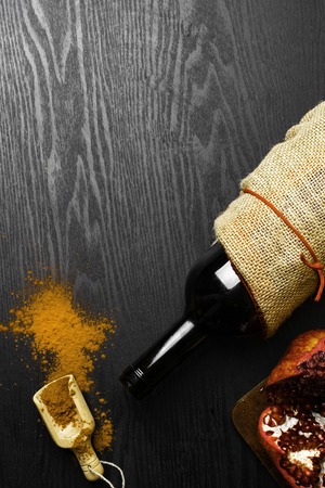 food rich with resveratrol and iron, red wine in bottle, pomegranate, cacao in wooden spoonの写真素材