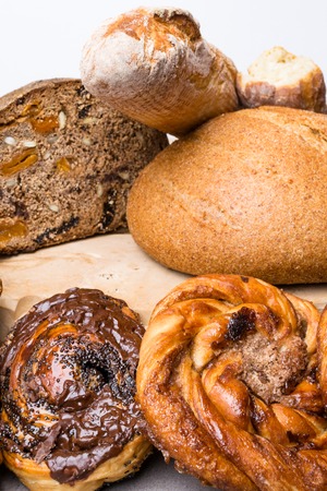 arrangement of different breads with plum, apricot, buns with poppy, chocolate, cinnamon at the...