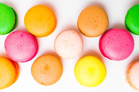 Sweet almond colorful pink, yellow, green, brown macaron or macaroon dessert cake isolated on white background. French sweet cookie. Minimal food bakery concept. top view, copy spaceの写真素材