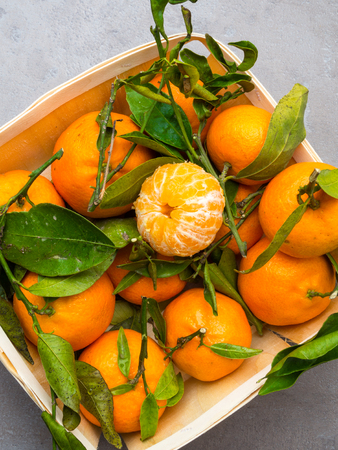 Fresh mandarins in wooden box isolated on grey background.の写真素材