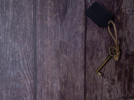 Home key with tag on wood table background, property concept, copy space, top viewの写真素材