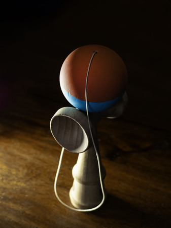 The original Kendama. An ancient, traditional, wooden Japanese skill toy for children. Has three cups, spike and ball, on the parquet.の写真素材