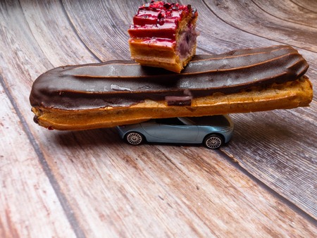 Eclair with chocolate fudge on a car, eclair order and delivery concept