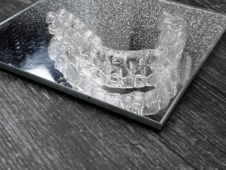 Inivisalign braces or aligner. A way to have a beautiful smile and white teeth on glass