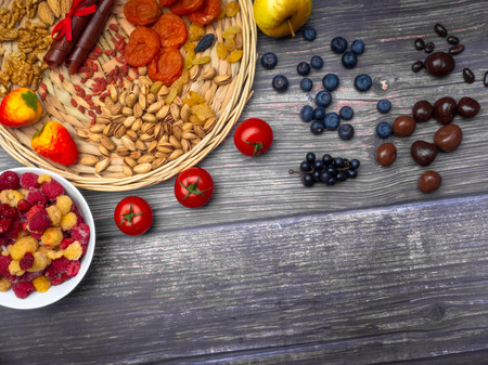 antioxidants, resveratrol food as grape, blueberry, strawberry, tomatoes, raspberry, apples, wild strawberry, cranberry candy, chocolate, dried apricot goji nuts on wooden surface food for brainの写真素材
