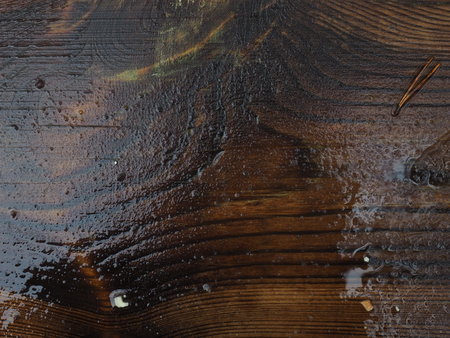 raining on wet dark wooden surface with reflectionの写真素材