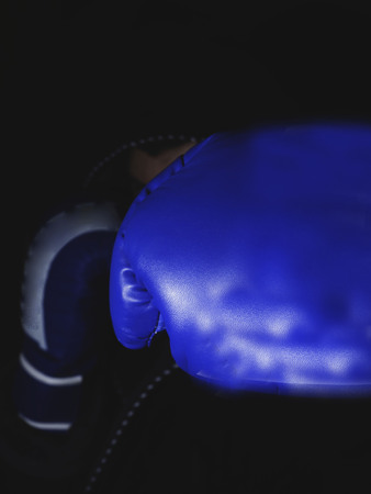 blurred boxer in the dark gym and boxing kick, focus on glove, power and win conceptの写真素材