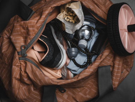 sport bag with fitness set, shoes, expander, roll for press, health snack food, nuts motivation and health lifestyle conceptの写真素材