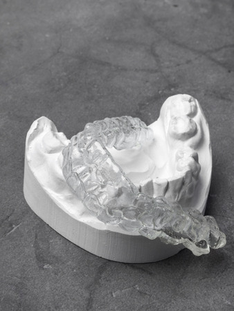 Gypsum model and transparent bite on grey background