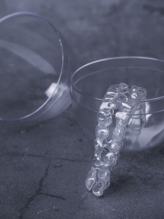 teeth aligners. Invisible brackets in transparent bowl. Shine smile conceptの写真素材