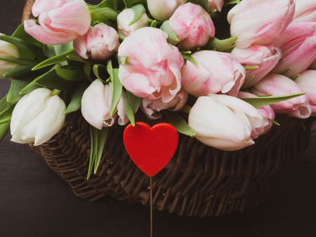 Huge bouquet of pink tulips in wicker basket. Postcard motif, with decorative heart, women day, 14th february, love conceptの写真素材