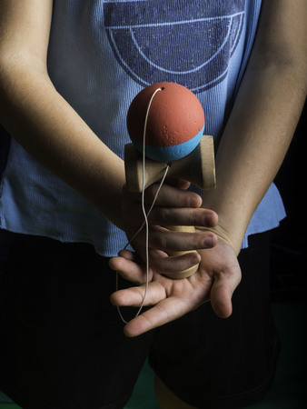 Classic Japanese game kendama, boy hands playing blue and pink color kendamaの写真素材