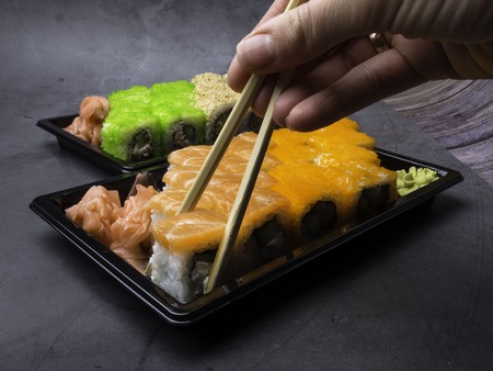 Japanese sushi on a dark background. Sushi rolls, pickled ginger, wasabi. Sushi set on a table. Space for text. sushi background. Asian or Japanese food.の写真素材