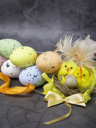 A Cute Easter Chick in a Nest Surrounded by Colorful Eggs, easter postcardの写真素材