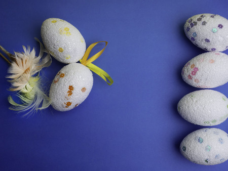 Easter eggs on blue background top view mockup, copy space