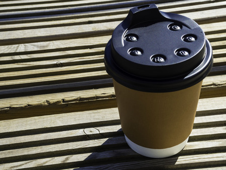 paper cup with lid. Coffe cup on wooden surface. Street coffee, take and go conceptの写真素材