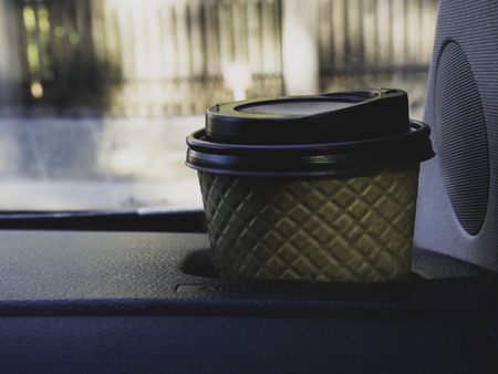 Paper cup on the front of the car. Background is blurred. Take and driveの写真素材