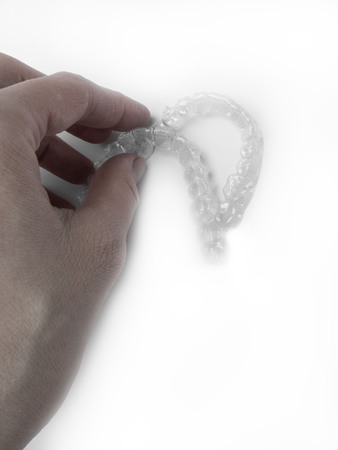 Woman holding mouthguard on white background