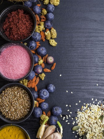 Ingredients for a healthy breakfast, berries, pomegranate powder, blueberry, sunflower seeds, pumpkin seeds, flax, black cumin seeds, The concept of natural organic food in season. Top viewの写真素材