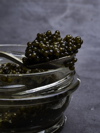 Jar with black caviar and a vintage spoon. Free space for textの写真素材