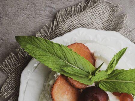Pavlova: A Cake Made From Layers of Meringue, Whipped Cream, and Fresh Berries and green mint leaf